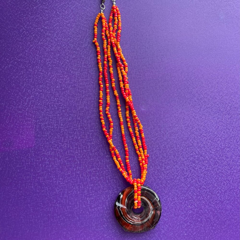Triple Strand Orange Beaded Necklace with Glass Pendant.